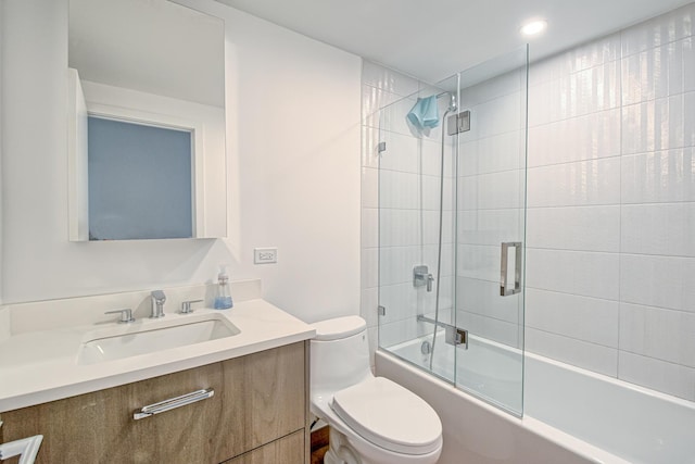 full bathroom featuring toilet, enclosed tub / shower combo, and vanity