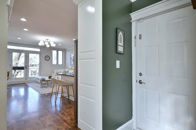 foyer entrance with dark wood finished floors, a notable chandelier, recessed lighting, and baseboards