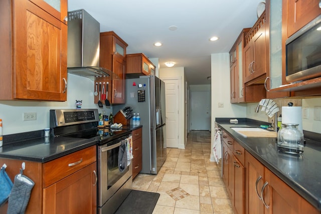 kitchen with recessed lighting, stainless steel appliances, wall chimney range hood, brown cabinetry, and glass insert cabinets