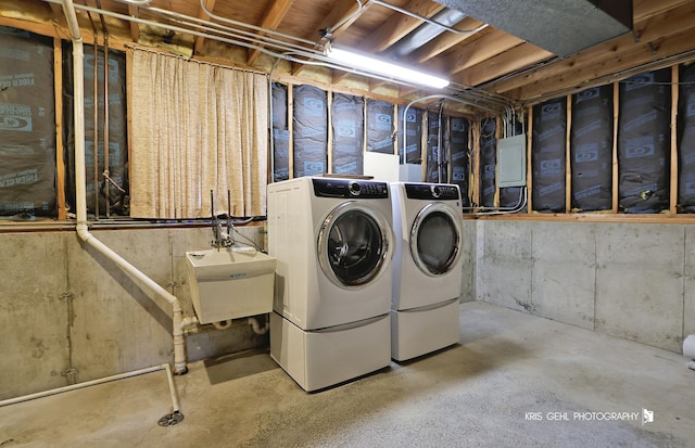 unfinished below grade area with washing machine and clothes dryer and a sink