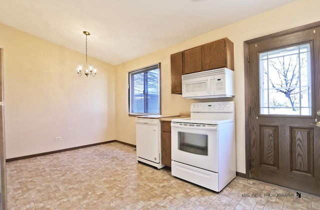 kitchen featuring white appliances, an inviting chandelier, light countertops, baseboards, and hanging light fixtures