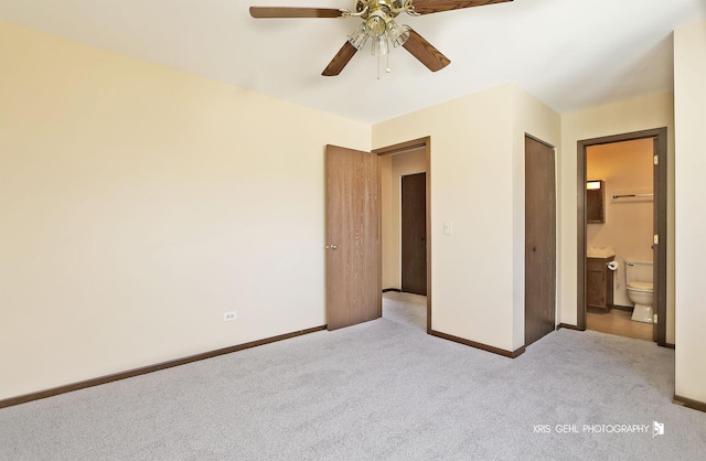 unfurnished bedroom with baseboards, carpet floors, connected bathroom, and a ceiling fan