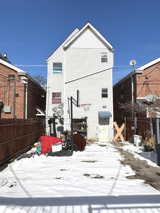 snow covered property with fence