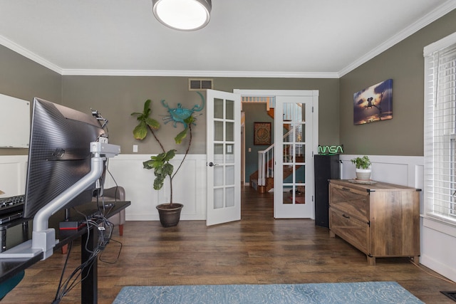 interior space with french doors, visible vents, ornamental molding, wainscoting, and wood finished floors