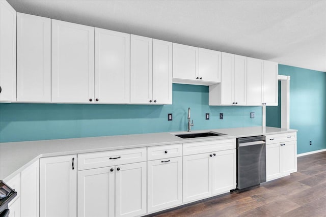 kitchen featuring dark wood finished floors, stainless steel dishwasher, a sink, and white cabinetry