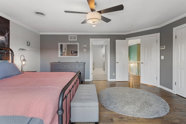 bedroom featuring ornamental molding, visible vents, baseboards, and wood finished floors