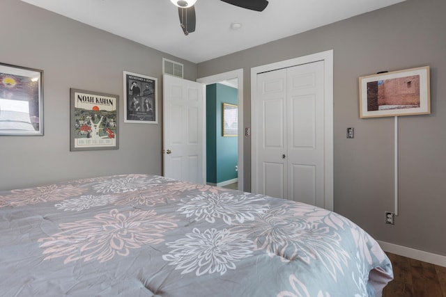 bedroom with ceiling fan, wood finished floors, visible vents, baseboards, and a closet