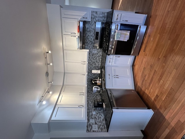 kitchen featuring dark countertops, wooden walls, and white cabinetry