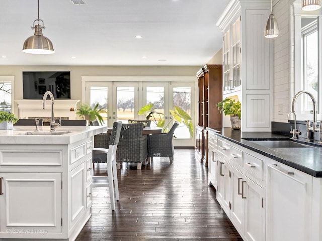 kitchen featuring white cabinetry, dark wood-style flooring, a sink, and french doors