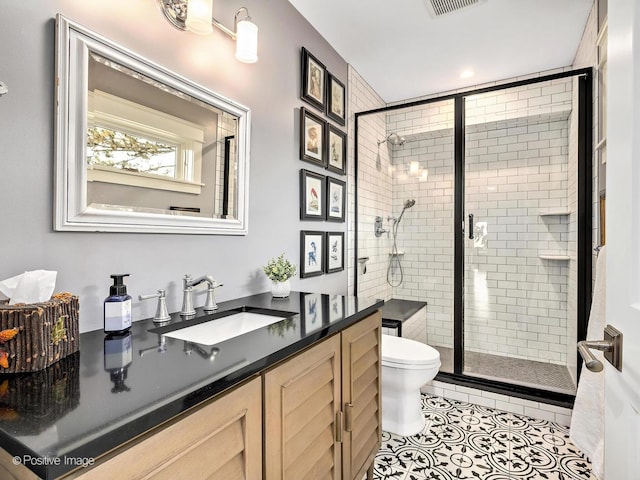 bathroom with vanity, a shower stall, toilet, and tile patterned floors