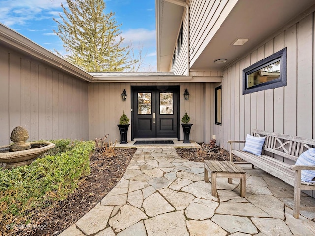 doorway to property featuring a patio, board and batten siding, and french doors