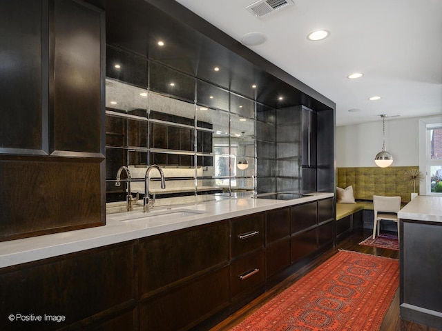 bar with visible vents, dark wood-style floors, black electric stovetop, a sink, and recessed lighting