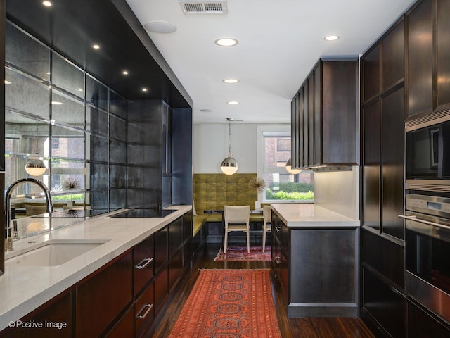 kitchen featuring dark wood-style floors, stainless steel appliances, a sink, and visible vents