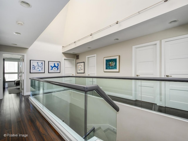 hall with dark wood-style flooring and baseboards