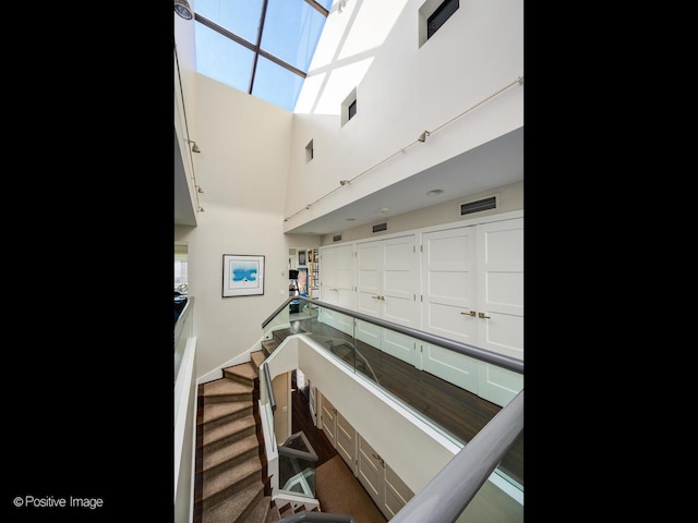 interior space featuring carpet flooring, visible vents, and a high ceiling