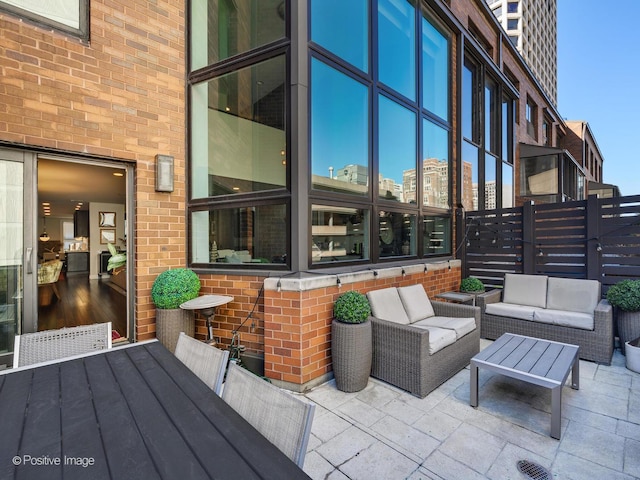 view of patio / terrace with an outdoor hangout area, a view of city, and fence