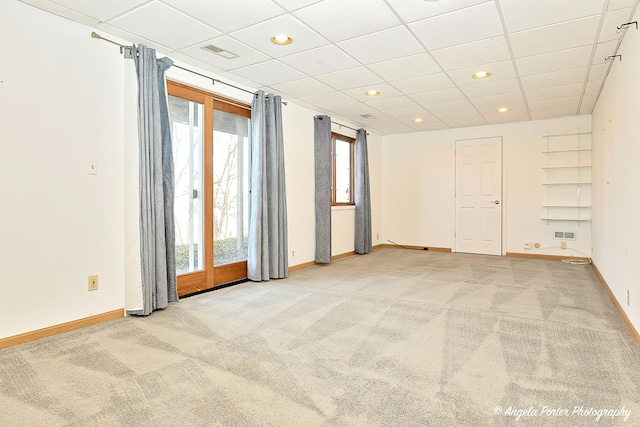 carpeted spare room featuring visible vents, baseboards, and a wealth of natural light