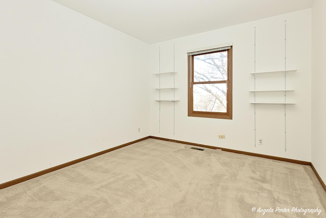 empty room with baseboards, carpet floors, and visible vents