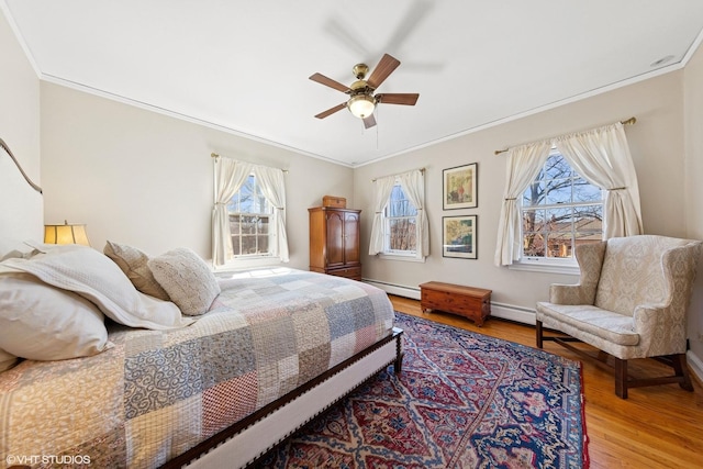 bedroom featuring crown molding, multiple windows, and wood finished floors