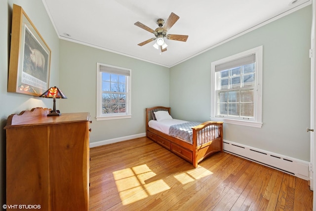 bedroom featuring a baseboard heating unit, ornamental molding, and hardwood / wood-style floors