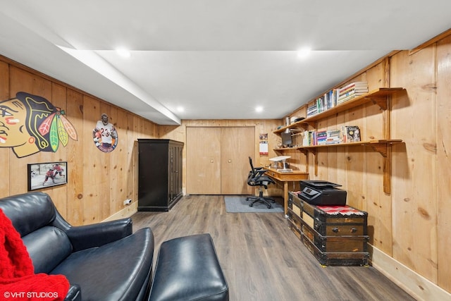 home office with light wood-style floors, wooden walls, and recessed lighting