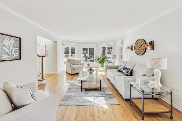 living room with ornamental molding, baseboards, light wood finished floors, and stairs