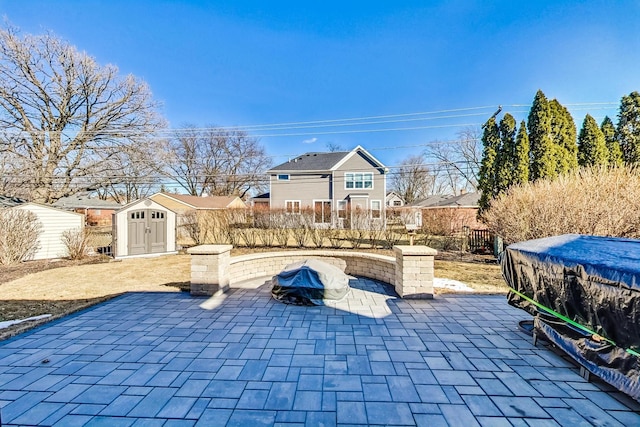 view of patio / terrace with an outbuilding, fence, and a storage shed