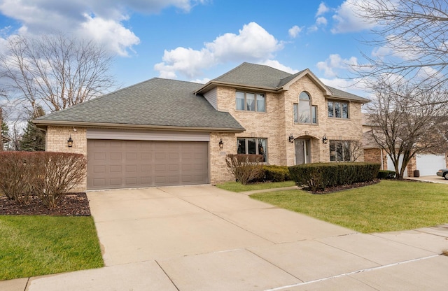 view of front of house with an attached garage, brick siding, driveway, and a front lawn