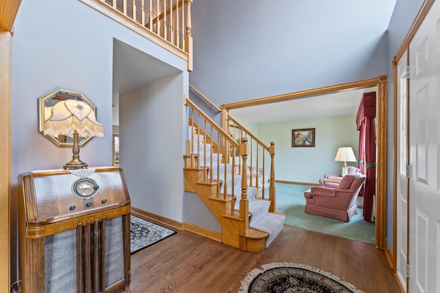 entryway with baseboards, a high ceiling, stairway, and dark wood-style flooring