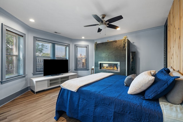 bedroom with ornamental molding, wood finished floors, visible vents, and baseboards