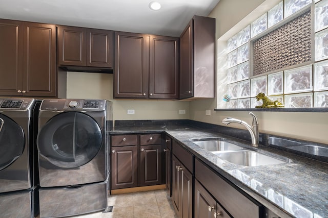 laundry room with a sink, light tile patterned floors, washing machine and dryer, and cabinet space