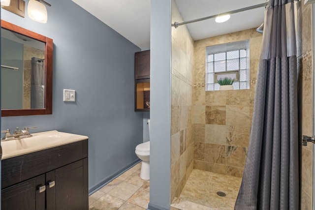 full bath with toilet, tiled shower, and vanity