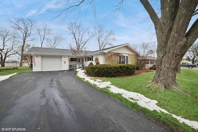 ranch-style house with aphalt driveway, a garage, and a front lawn