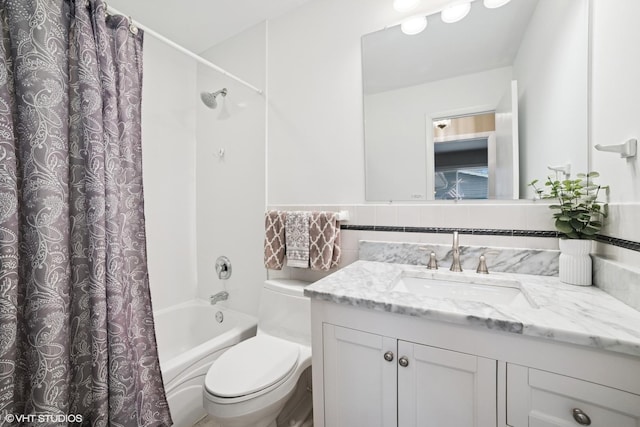 full bathroom featuring toilet, shower / bathtub combination with curtain, tile walls, and vanity