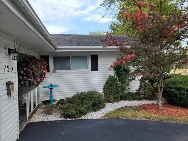 view of side of property with a shingled roof