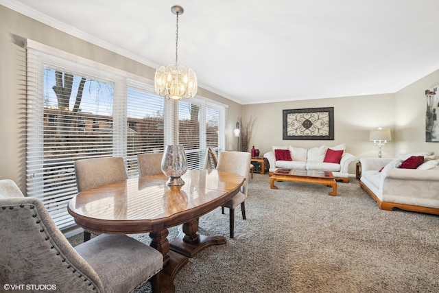 dining area with a notable chandelier, crown molding, and carpet flooring