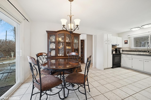 dining space featuring light tile patterned floors and an inviting chandelier