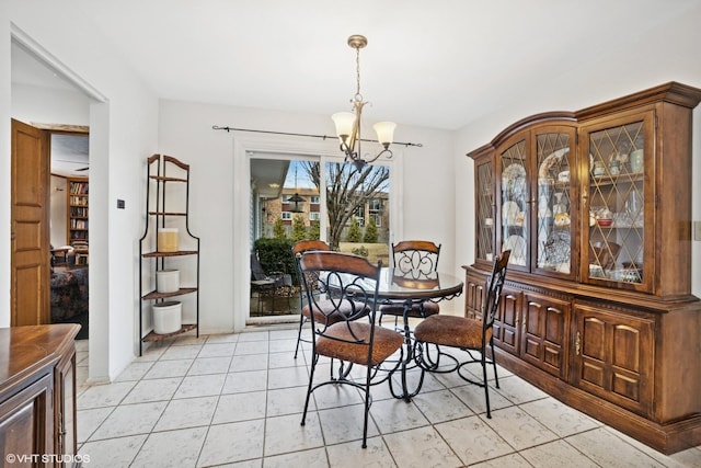 dining space with light tile patterned flooring and a notable chandelier