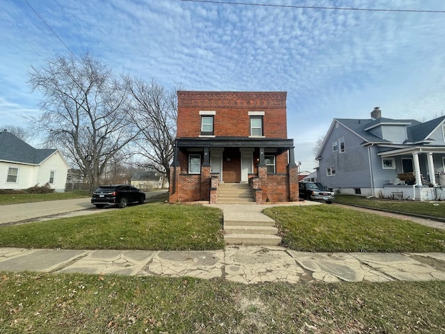 view of front of house with brick siding, a front lawn, and a porch