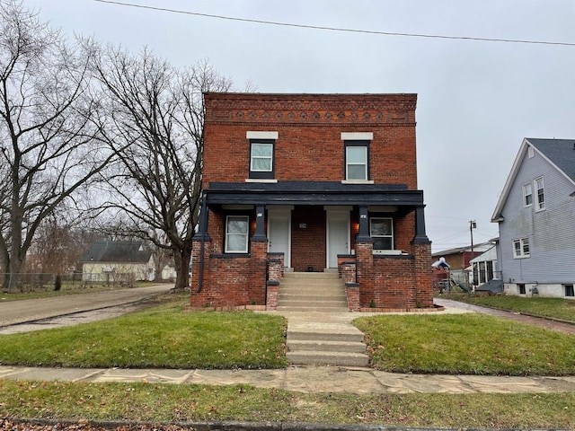 view of front of home with covered porch, a front yard, and brick siding