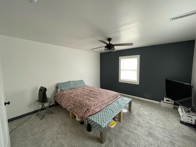 carpeted bedroom with visible vents, baseboards, and ceiling fan