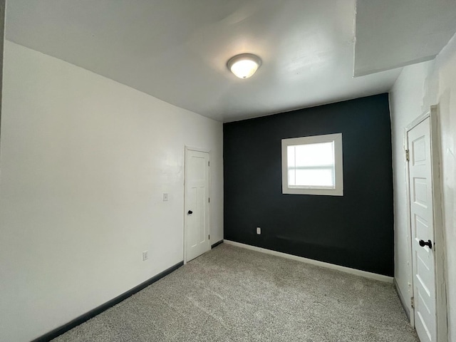 unfurnished room featuring carpet floors and baseboards