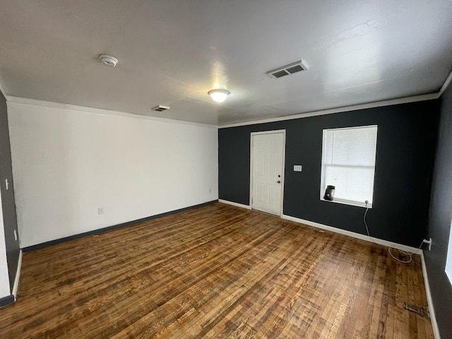 unfurnished room with dark wood-style floors, baseboards, and visible vents