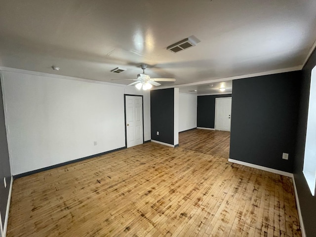 empty room featuring baseboards, visible vents, ceiling fan, and light wood finished floors