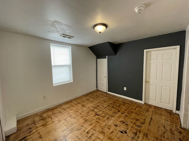 bonus room with lofted ceiling, wood-type flooring, visible vents, and baseboards