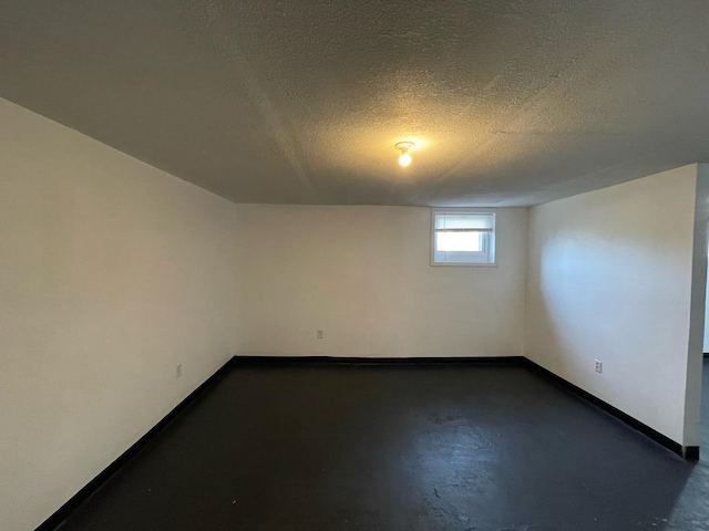 basement featuring a textured ceiling and baseboards