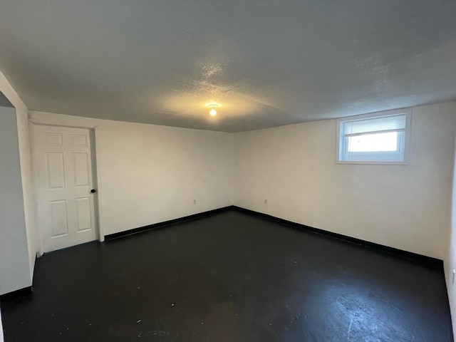 below grade area featuring a textured ceiling and baseboards