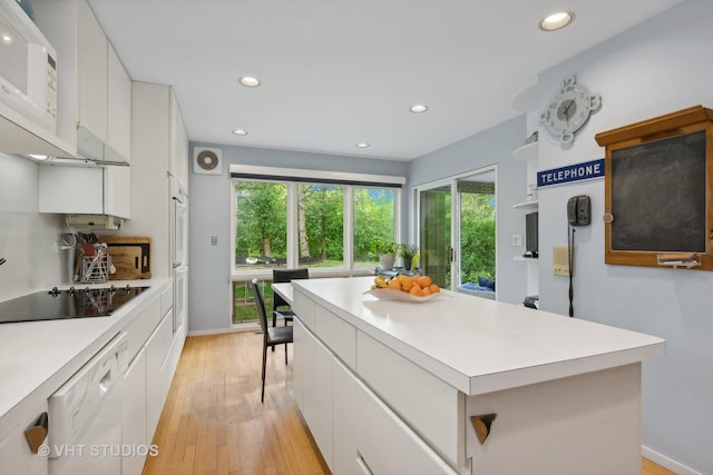 kitchen with light countertops, white appliances, and white cabinetry