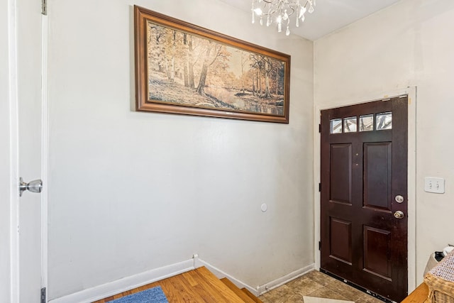 entrance foyer with an inviting chandelier and baseboards