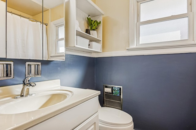 full bathroom with curtained shower, vanity, and toilet